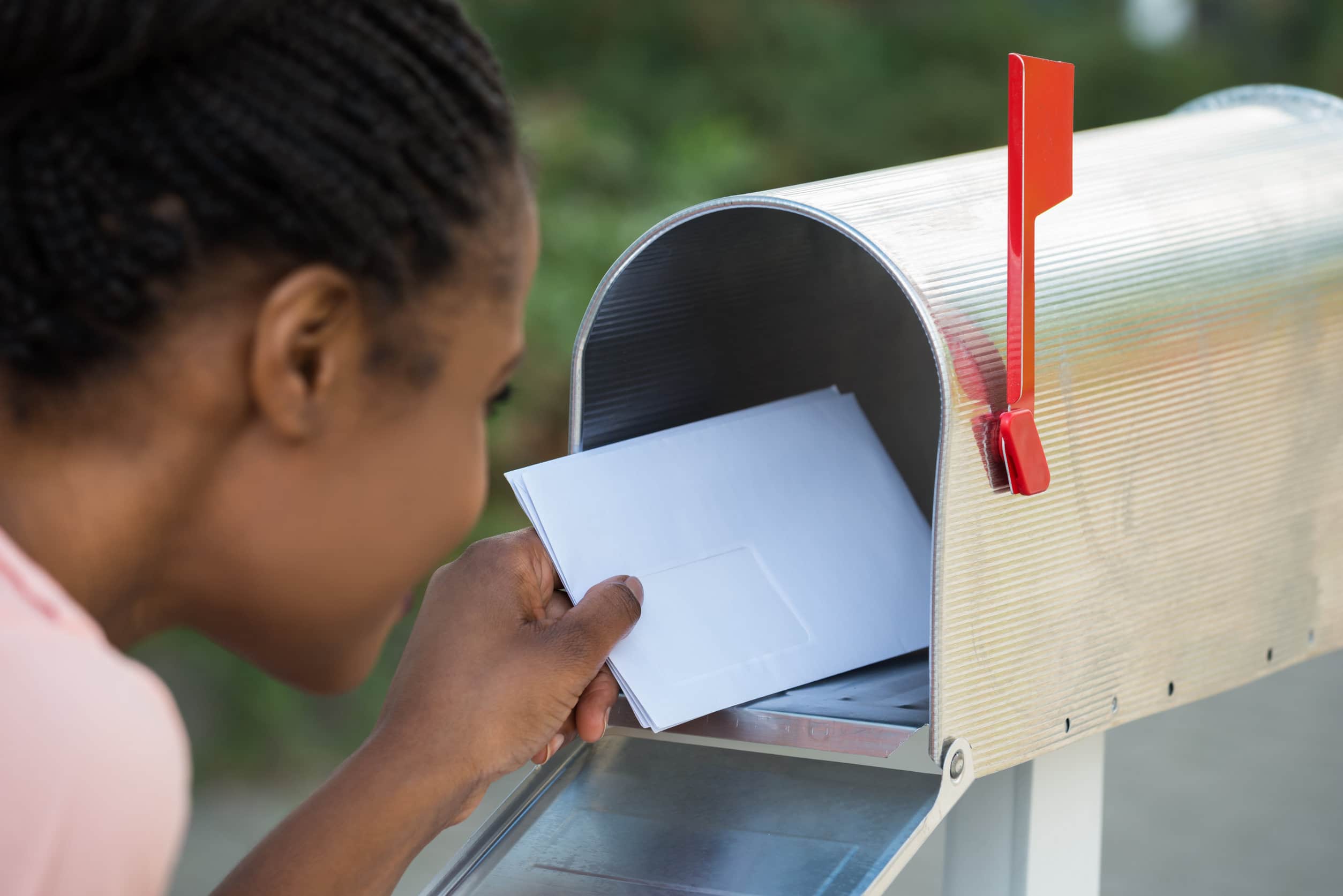 Woman Putting Letter In Mailbox