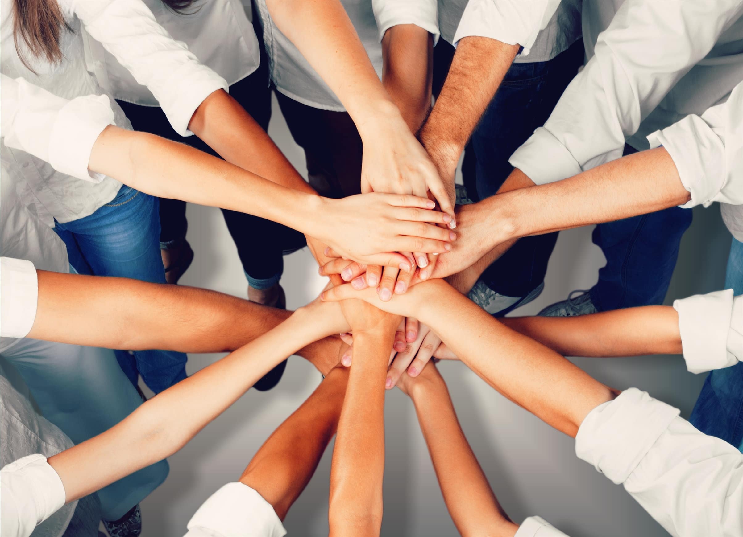 Group of people stacking hands together